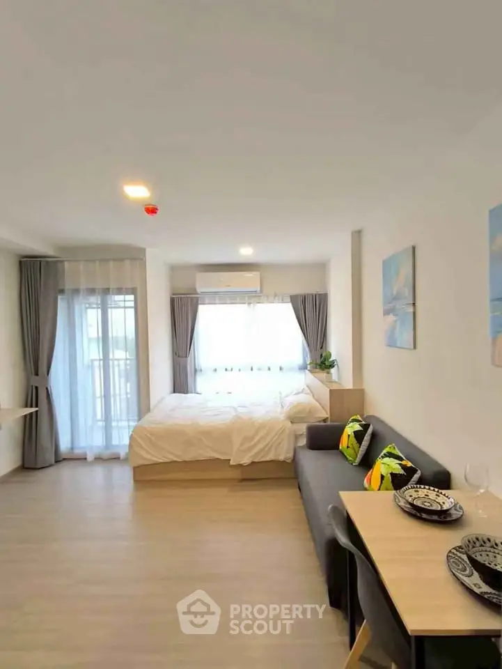 Modern studio apartment with cozy living area and stylish decor, featuring a comfortable bed and dining space.
