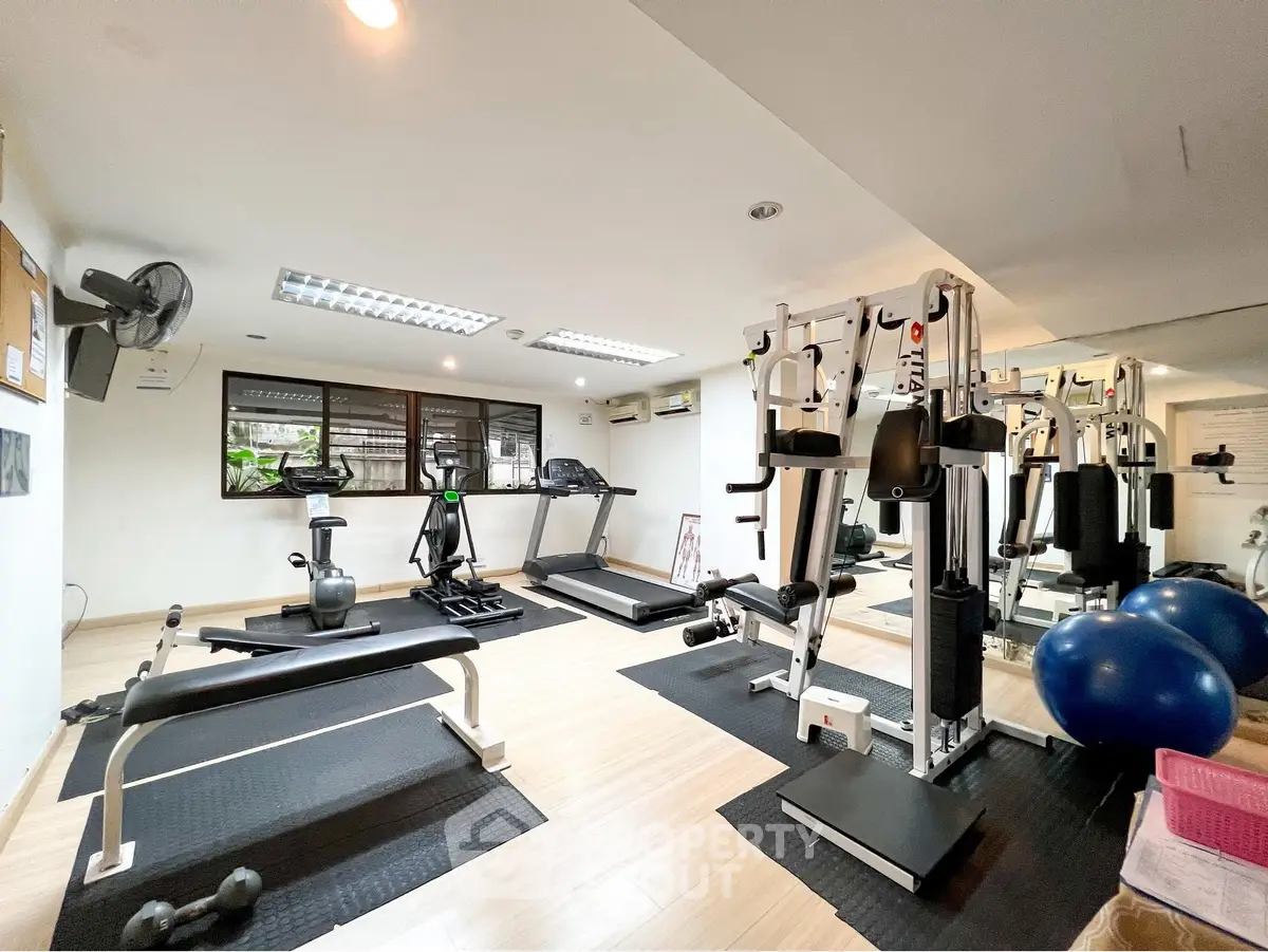 Modern gym with state-of-the-art equipment and bright natural lighting, perfect for fitness enthusiasts.