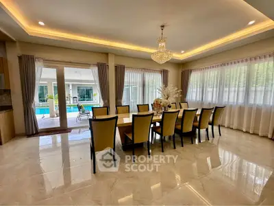 Luxurious dining room with elegant chandelier and pool view, perfect for entertaining guests.