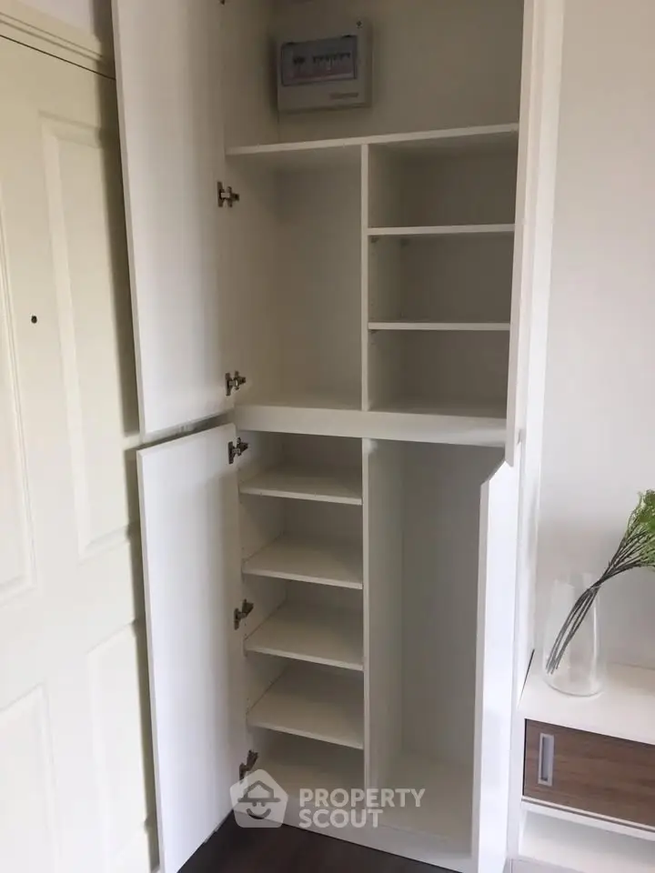 Spacious white storage cabinet with multiple shelves in modern interior.