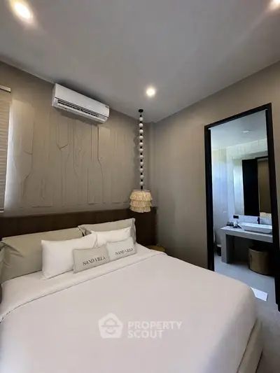 Modern bedroom with ensuite bathroom in Sand Villa, featuring elegant decor and air conditioning.