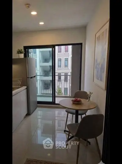 Modern kitchen with dining area and balcony view in urban apartment