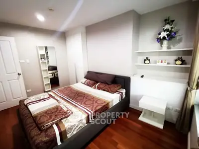 Cozy bedroom with modern decor and hardwood floors in a stylish apartment.