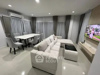 Spacious modern living room with elegant white sofa and dining area, perfect for entertaining.