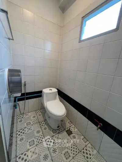 Modern bathroom with stylish patterned tiles and a sleek toilet design.