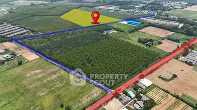Aerial view of expansive land plot with marked boundaries and location pin, ideal for development.