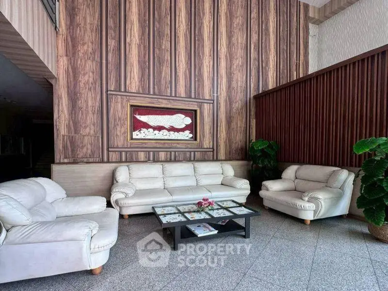 Elegant lobby with plush white sofas and modern wood paneling, perfect for welcoming guests in style.