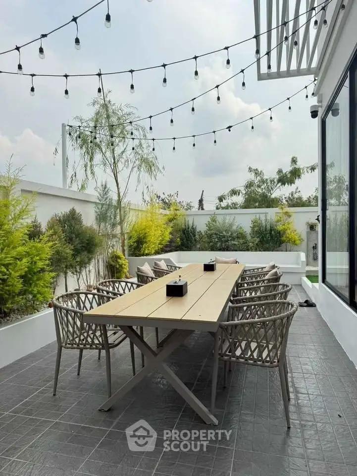 Stunning outdoor patio with elegant dining setup and string lights, perfect for entertaining.