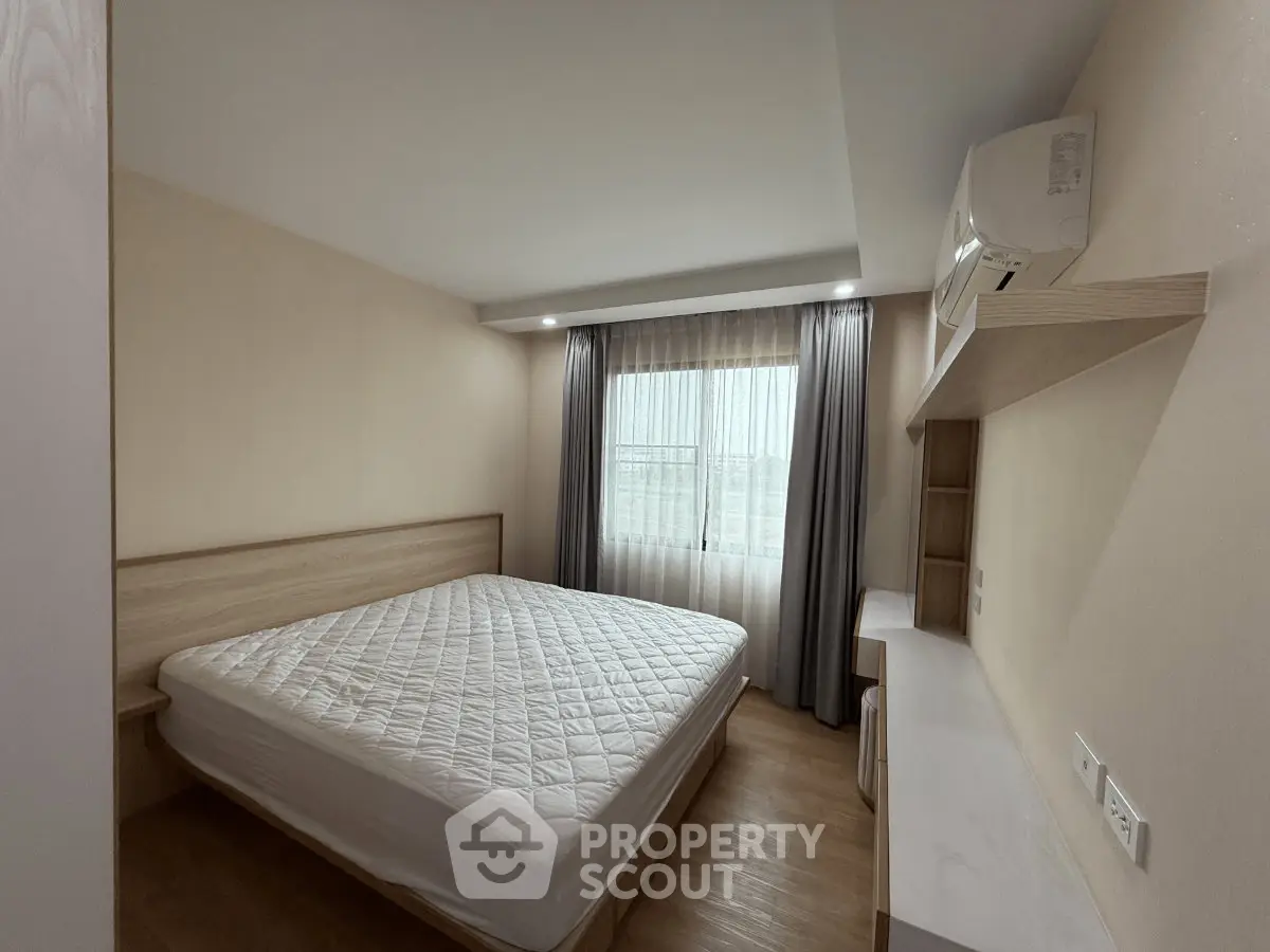 Modern bedroom with minimalist design, featuring a large bed and built-in air conditioning.