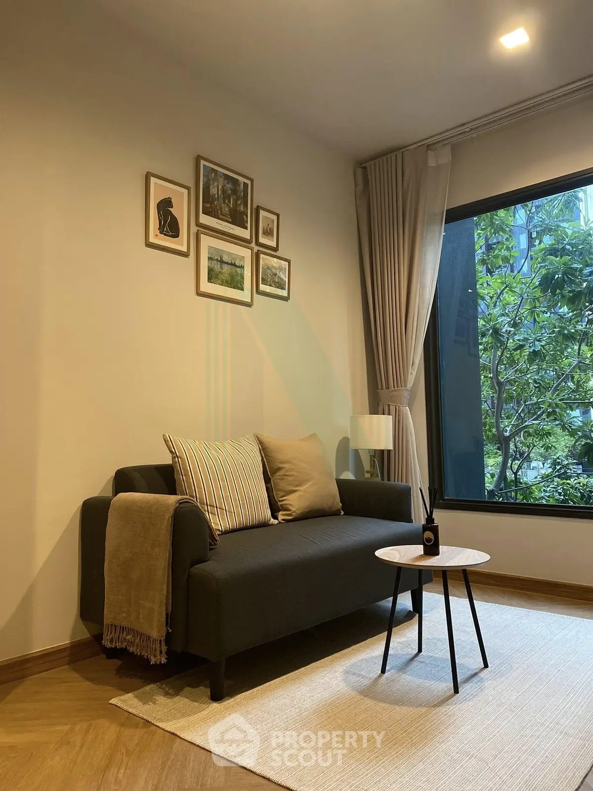 Cozy living room with modern sofa, stylish decor, and large window view.