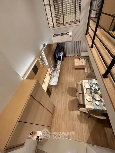 Modern loft-style living room with dining area, high ceiling, and elegant decor