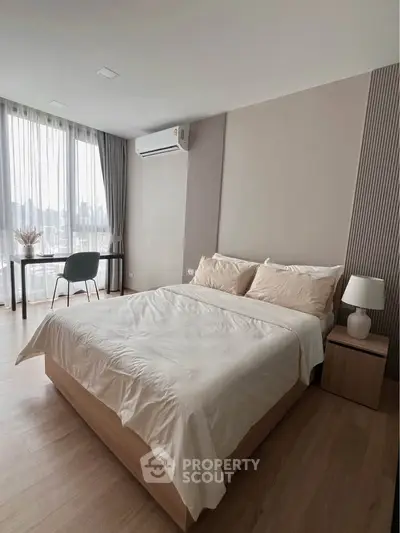 Modern bedroom with large windows and stylish decor in a high-rise apartment.