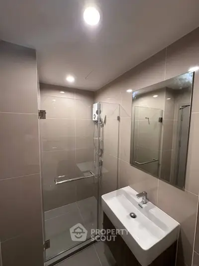Modern bathroom with sleek shower and stylish sink in contemporary apartment.