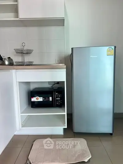 Modern kitchen with sleek fridge and microwave in compact layout