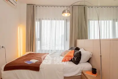 Cozy bedroom with modern decor and large windows offering ample natural light.