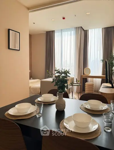 Modern dining area with elegant table setting and view into cozy bedroom
