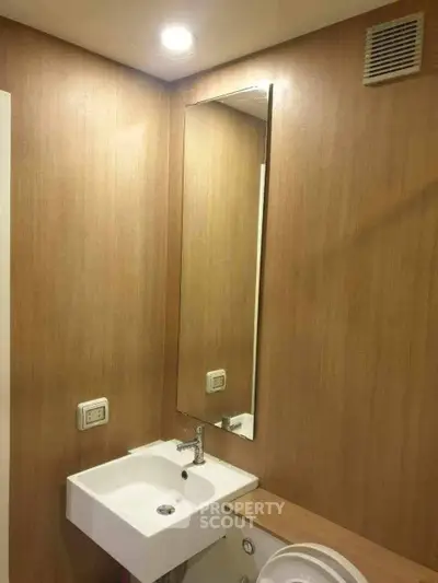 Modern bathroom with sleek sink and wooden paneling, ideal for contemporary living spaces.