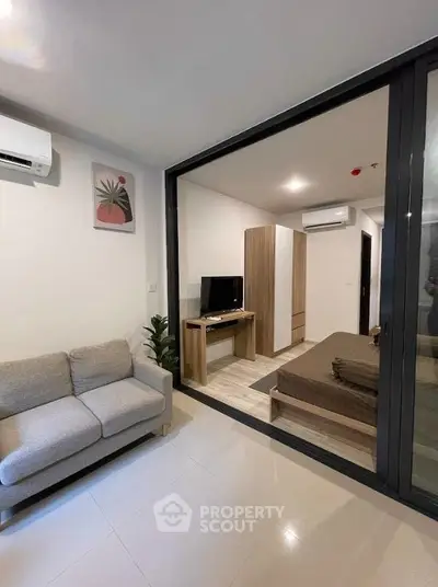 Modern studio apartment with glass partition and cozy furnishings