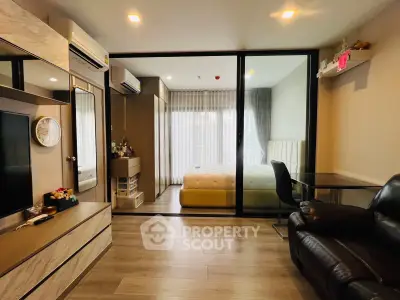 Modern studio apartment with glass partition, cozy living area, and stylish bedroom.