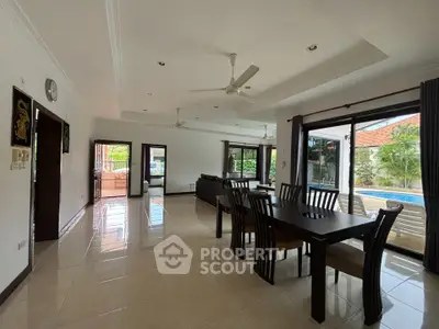 Spacious open-plan living and dining area with pool view and modern furnishings.