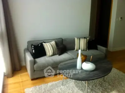 Stylish modern living room with cozy gray sofa and chic coffee table, perfect for relaxation.