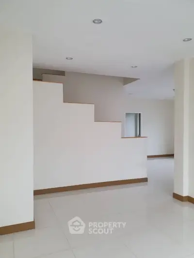 Spacious modern interior with sleek staircase and minimalist design.