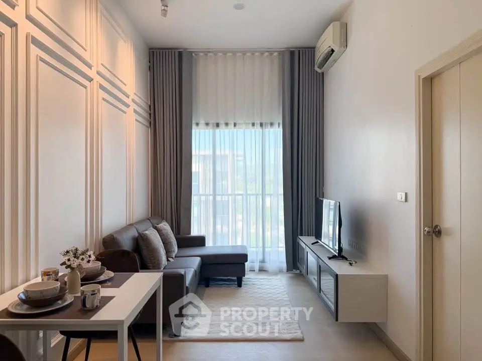 Modern living room with elegant decor and natural light, featuring a cozy sofa and stylish dining area.