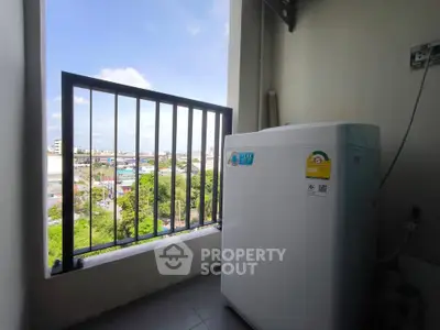Compact balcony with washing machine and scenic city view, perfect for urban living convenience.