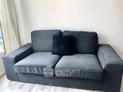 Modern gray sofa in a bright living room with natural light and minimalist decor.