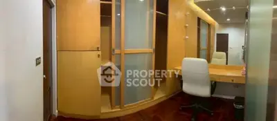 Spacious study room with built-in wooden cabinets and modern desk chair, perfect for productivity.