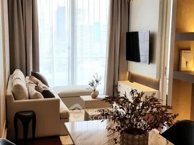 Modern living room with large windows and city view, featuring elegant decor and comfortable seating.