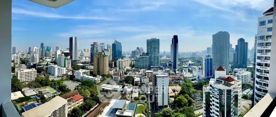 Stunning panoramic cityscape view from a high-rise balcony showcasing urban skyline and lush greenery.