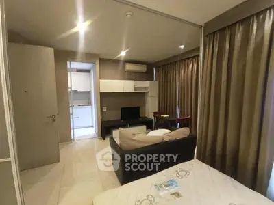 Modern studio apartment with open layout, featuring cozy living area and compact kitchen.
