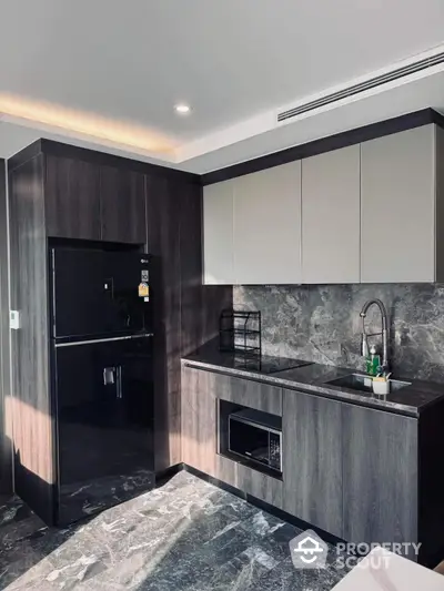 Modern kitchen with sleek dark cabinets and marble backsplash