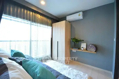 Modern bedroom with large window, stylish decor, and air conditioning unit.