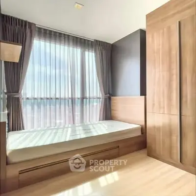 Modern bedroom with large window and wooden wardrobe, featuring natural light and minimalist design.
