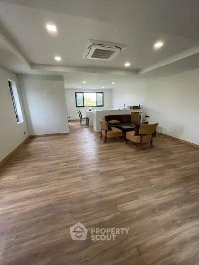 Spacious modern living room with wooden flooring and recessed lighting