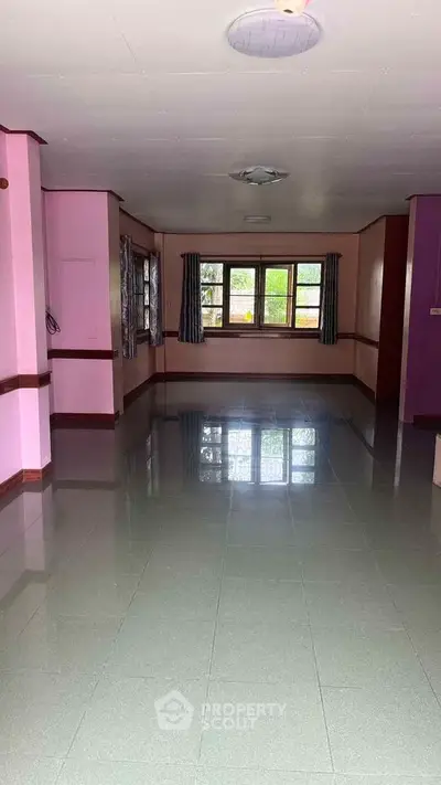 Spacious empty room with large windows and glossy tiled floor