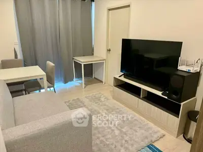 Modern living room with sleek furniture and large TV, perfect for relaxation and entertainment.
