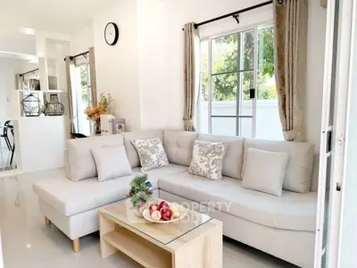 Bright and cozy living room with modern decor and large windows.