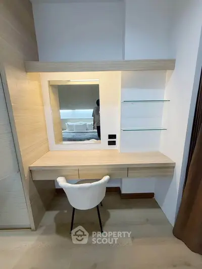 Modern bedroom with stylish vanity desk and mirror, featuring sleek wooden design and elegant chair.