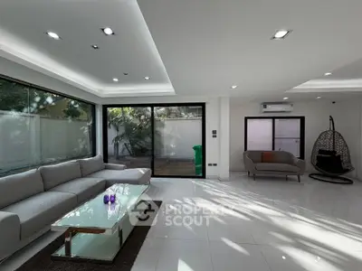 Spacious modern living room with large windows and elegant furniture
