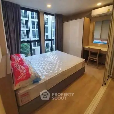 Modern bedroom with large windows and stylish furniture in a high-rise apartment.