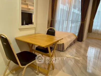 Cozy studio apartment with modern furnishings and large windows for natural light.