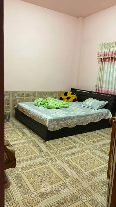 Cozy bedroom with patterned flooring and large bed, perfect for relaxation.