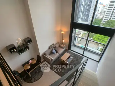 Modern loft apartment with high ceilings and large windows offering stunning city views.