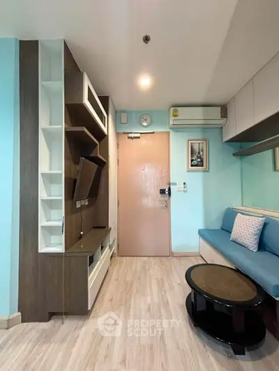 Modern living room with stylish furniture and wall-mounted TV in a cozy apartment.