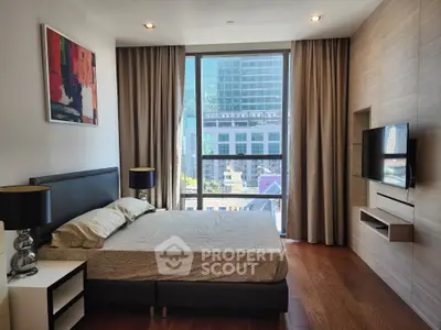 Modern bedroom with city view, stylish decor, and natural light.