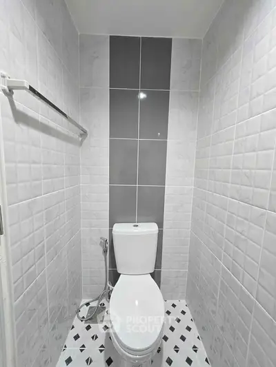 Modern bathroom with sleek tiles and contemporary toilet design.