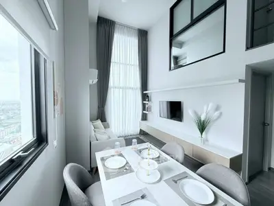 Modern high-ceiling living room with dining area and large windows